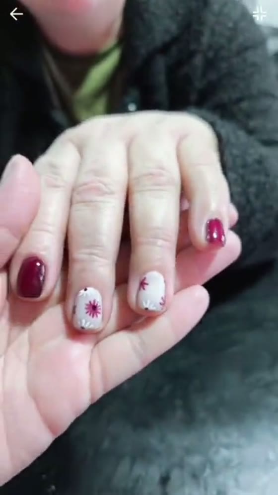Uñas rojas con diseño de flores hechas en REVIVE